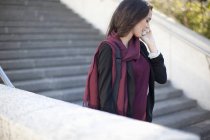 Junge Geschäftsfrau chattet auf Smartphone im Treppenhaus der Stadt — Stockfoto