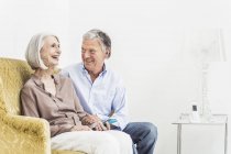 Seniorenpaar entspannt sich zu Hause und lächelt — Stockfoto