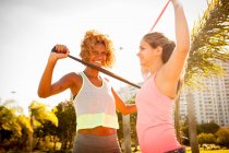 Двоє молодих друзів-жінок тренуються з групами вправ в парку — стокове фото