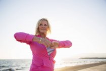 Mulher sênior alongamento por praia — Fotografia de Stock