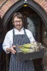 Portrait of chef holding box of asparagus — Stock Photo