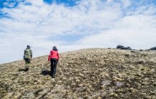Visão traseira de duas jovens mulheres caminhando montanha acima — Fotografia de Stock