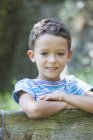 Портрет мальчика, опирающегося на садовый забор — стоковое фото