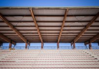 Estádio esporte assentos com telhado de estanho contra o céu azul — Fotografia de Stock