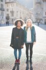 Portrait of two female friends in town square — Stock Photo