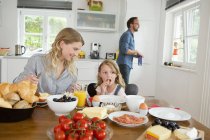 Mother and daughter eating at kitchen table — Stock Photo
