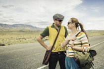 Casal estilo retro olhando um para o outro na beira da estrada, Cody, Wyoming, EUA — Fotografia de Stock