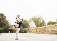 Romantique jeune homme levant petite amie dans le parc — Photo de stock