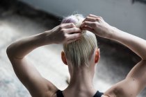 Femme attachant les cheveux en studio — Photo de stock