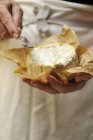 Обрізане зображення людини, що тримає козячий сир і сирний ніж — стокове фото