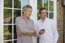 Erwachsener Vater und Sohn, zusammen stehen, reden, draußen — Stockfoto