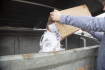 Adolescente vaciando residuos de papel a la papelera de reciclaje - foto de stock