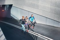 Trois coureuses qui courent dans le métro de la ville — Photo de stock