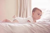 Bambino sdraiato sul letto, concentrazione selettiva — Foto stock