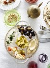 Still life dish of pickled vegetables and chillies with hummus — Stock Photo