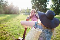 Romantic young couple carrying rug for picnic in park — Stock Photo