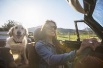 Mature woman and dog, in convertible car — Stock Photo