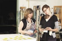 Donne che discutono di design nel laboratorio tessile di stampa a mano — Foto stock