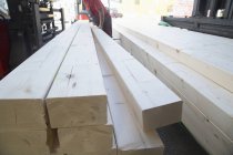 Работник мужского склада кладет деревянные доски для хозяйственного магазина — стоковое фото