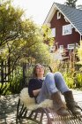 Взрослая женщина отдыхает на шезлонге на деревянном настиле — стоковое фото