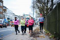 Cinque corridori donne che corrono sul marciapiede della città — Foto stock