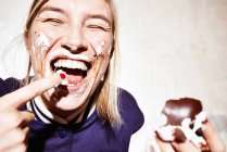 Close up of young woman with chocolate marshmallow on face — Stock Photo