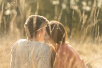 Молодая пара целуется в высокой траве — стоковое фото