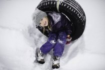Overhead portrait of girl on tire swing in snow — Stock Photo