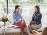 Jovem empresária entrevistando mulher adulta média no sofá — Fotografia de Stock