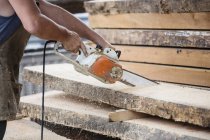 Carpinteiro serrar prancha de madeira — Fotografia de Stock