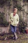 Porträt einer reifen Frau, die sich im Garten auf Spaten stützt — Stockfoto