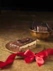 Chocolate dessert slice with red ribbon — Stock Photo