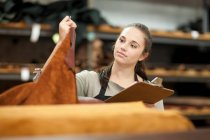 Worker looking at roll of leather — Stock Photo