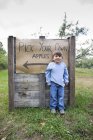 Portrait of cute boy in front of pick your own sign — Stock Photo