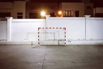 Portería de fútbol por pared blanca en la noche - foto de stock