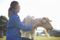 Сільськогосподарський працівник, який прагне козлів на фермі — стокове фото