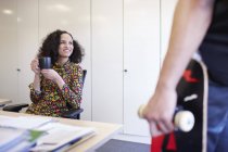 Ділова жінка спілкується з колегою за офісним столом — стокове фото