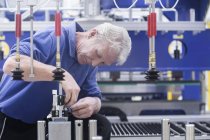 Инженер, работающий над управлением электрическими компонентами на машиностроительном заводе — стоковое фото