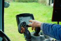 Hand of farmer using computer touchscreen in tractor — Stock Photo