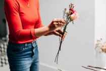 Immagine ritagliata di fiorista femminile che tiene fiori recisi in negozio di fiori — Foto stock