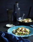 Table with bowl of potato gnocchi and broad beans — Stock Photo