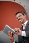 Uomo d'affari sorridente guardando tablet digitale — Foto stock