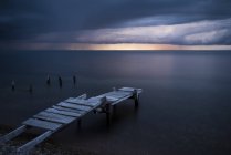 Lunga esposizione colpo di molo sulla spiaggia al tramonto — Foto stock