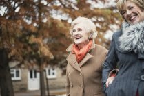 Seniorin und ältere Tochter gehen ins Freie — Stockfoto