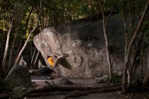 Rock climber scaling boulder face — Stock Photo