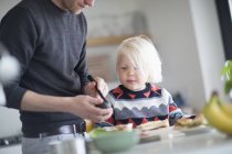 Vater und Sohn bereiten zu Hause in der Küche Essen zu — Stockfoto