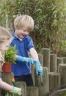 Escola menino e menina plantando no jardim — Fotografia de Stock