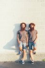 Портрет идентичных взрослых близнецов-мужчин с рыжими волосами и бородами у белой стены — стоковое фото