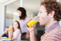 Мужчина пьет апельсиновый сок — стоковое фото