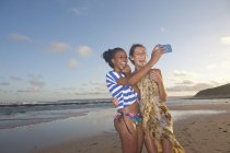 Jeunes amies sur la plage prenant selfie — Photo de stock
